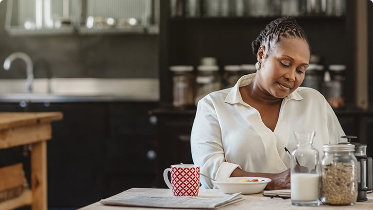 Person sitting at a table with food and a drink.